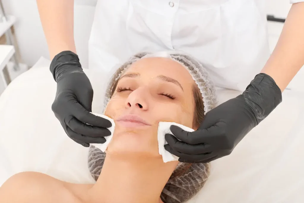 Fotografía en primer plano de una mujer sonriente mostrando los notables beneficios de la limpieza facial en un consultorio clínico de Quito.