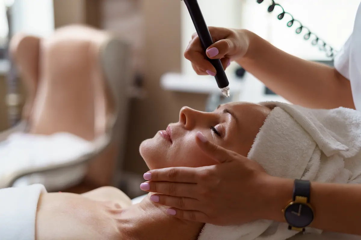 Primer plano de aplicación precisa de ácido hialurónico en labios por una especialista en medico estetica.