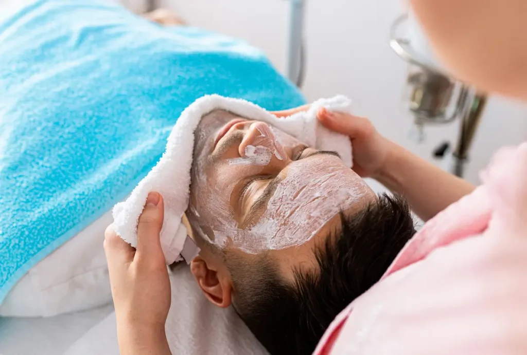 Vista de primer plano de una paciente sonriente recibiendo una limpieza facial profunda en una clínica dermatológica en Quito.