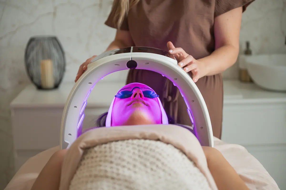 Mujer recibiendo sesión de fototerapia led con mascarilla de luz sobre el rostro